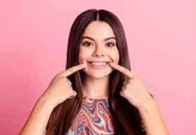 Woman pointing to her smile