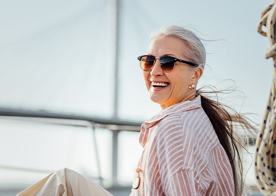Woman with sunglasses smiling on boat