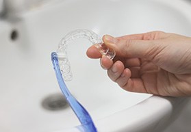 Patient cleaning clear aligner with toothbrush