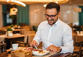 Man smiling while enjoying meal at restaurant