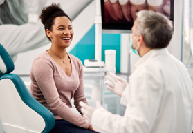 Young female patient speaking to dentist